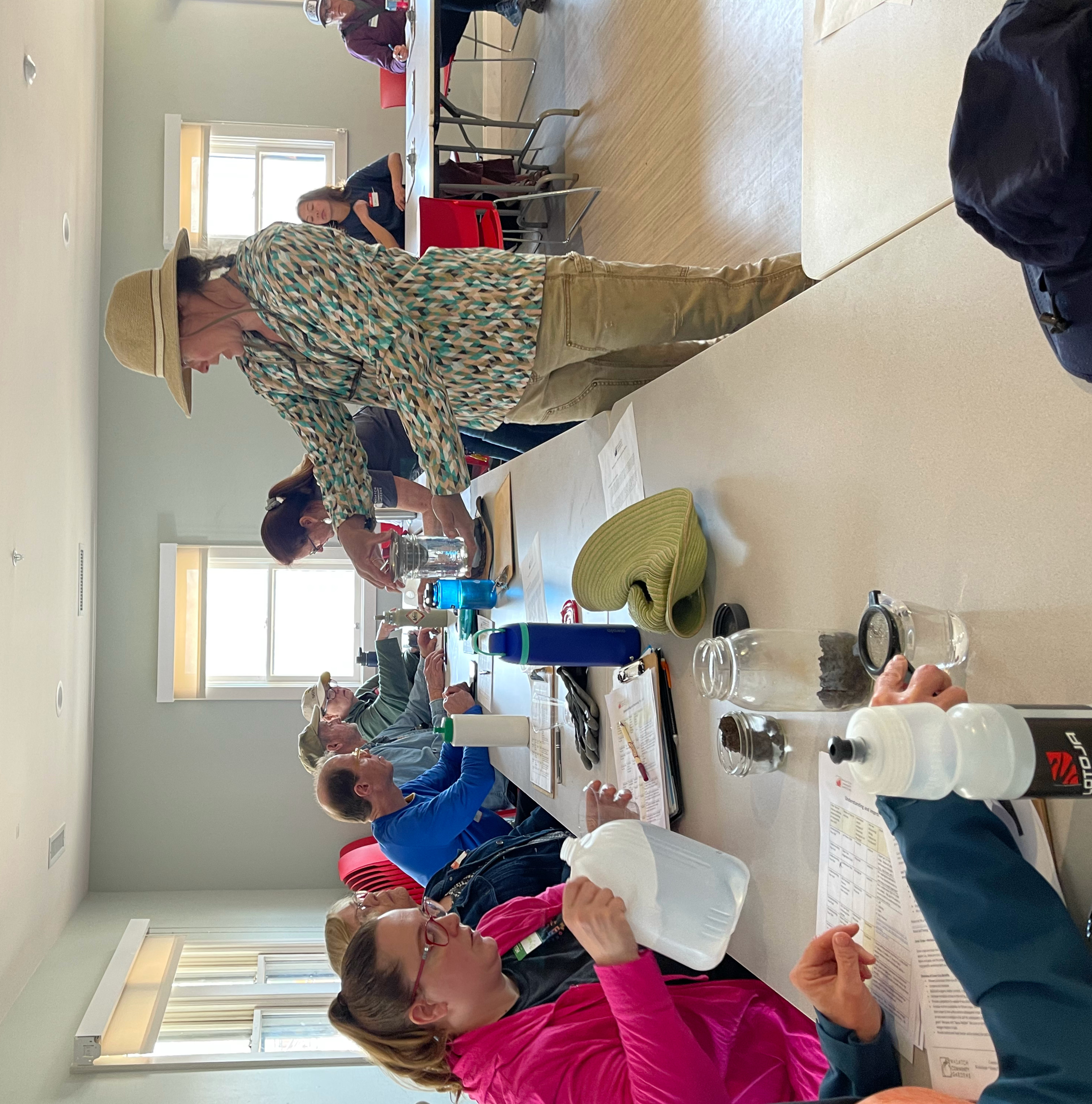 Teacher demonstrating soil jar test to students in classroom