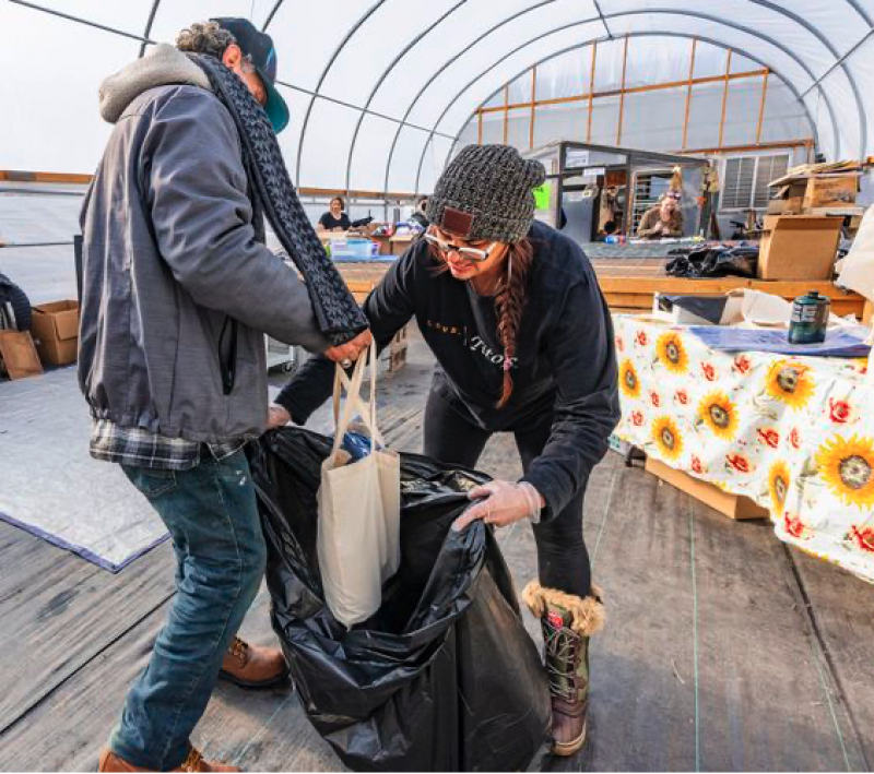 (Rick Egan | The Salt Lake Tribune) Advocate Coco Giles helps Billy Ray Bratcher load supplies into a trash bag that he can carry to his camp from the Coconut Hut, at Wasatch Community Gardens&#039; Green Phoenix Farm, on Wednesday Jan. 4, 2023.